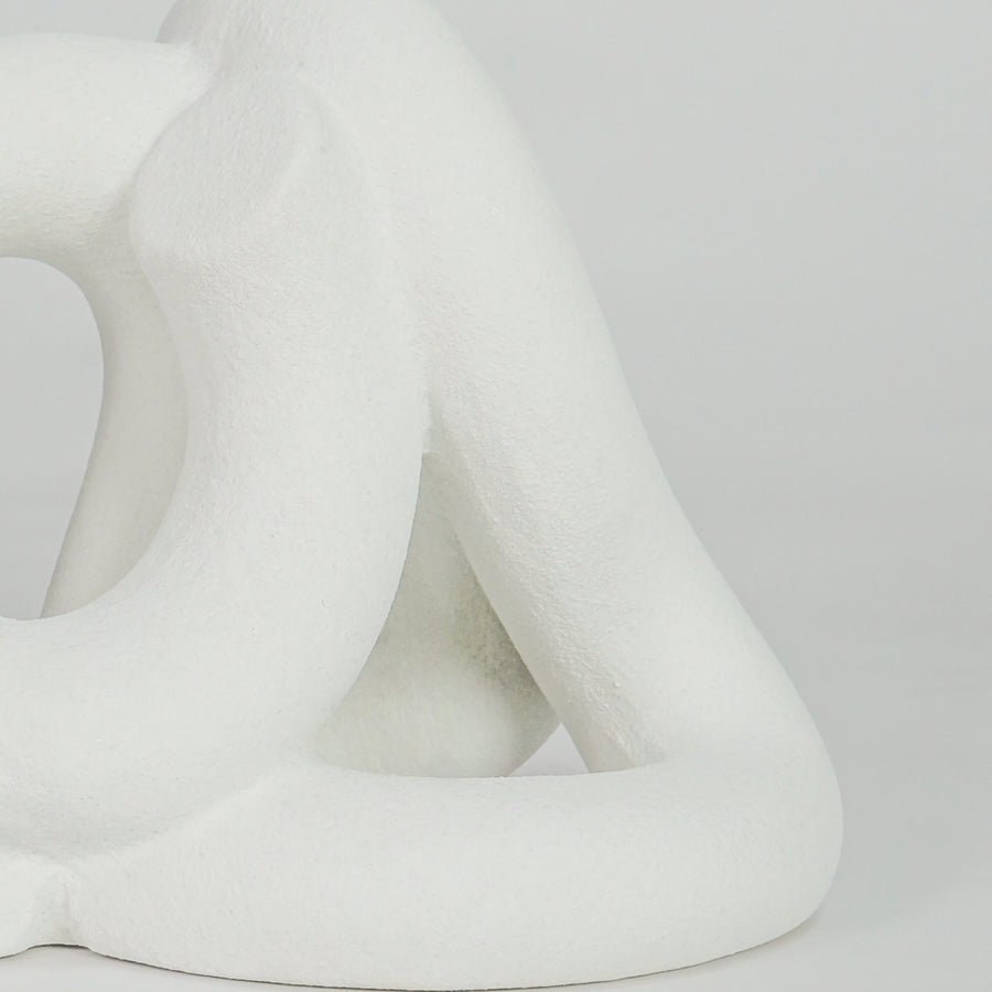 Closeup image of white ceramic abstract loop sculpture for modern tabletop decor styling with elegant matte finish.