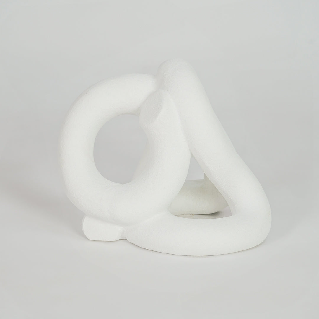 White abstract ceramic sculpture on white background for elegant modern shelf decor styling.