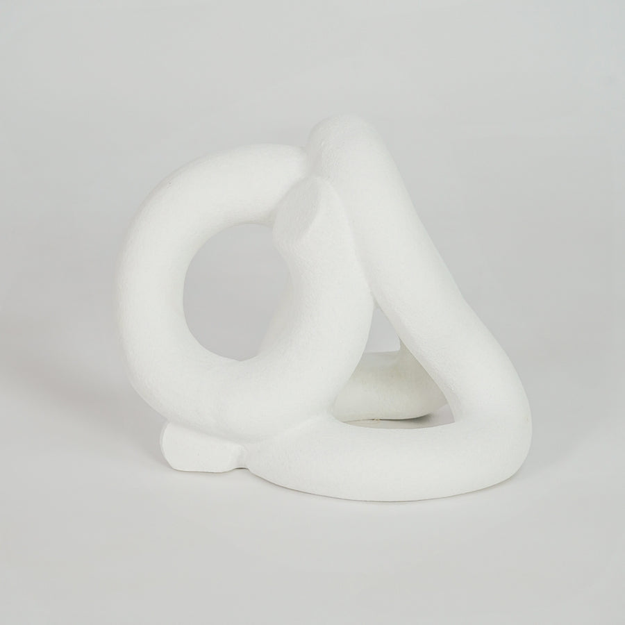 White abstract ceramic sculpture on white background for elegant modern shelf decor styling.
