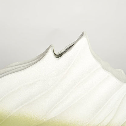 Close up view white and green ceramic vase showing sculpted wave texture matte finish decorative ceramic accent.