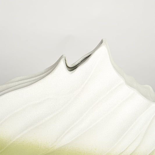 Close up view white and green ceramic vase showing sculpted wave texture matte finish decorative ceramic accent.