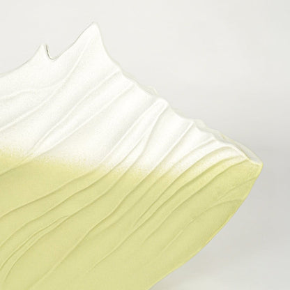 Close up view artistic ceramic vase showing gradient white to green finish sculpted surface decorative accent for home styling.