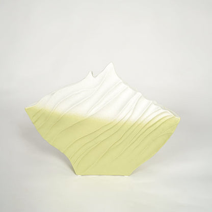 White and green decorative ceramic vase on white background modern home decor accent piece for console table styling.