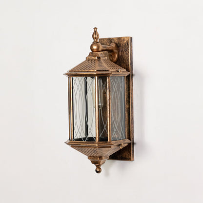 Antique gold metal outdoor wall lantern switched off on white background emphasizing detailed glass panels and metal finish.
