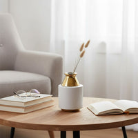 White and gold modern ceramic vase styled on a marble surface ideal for elegant home decor accents and premium interior styling.