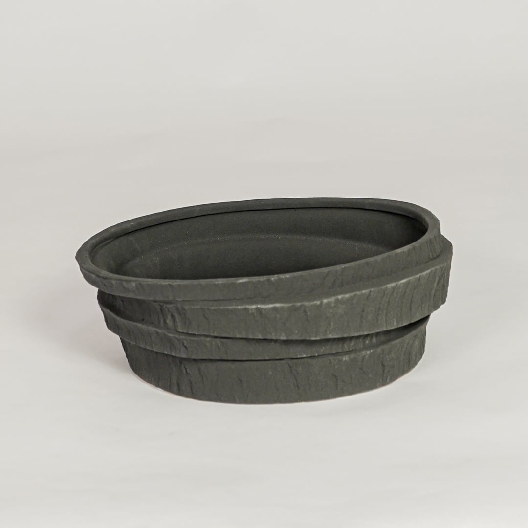 Modern black ceramic decorative bowl with textured stone design ideal for fruit display dining table centerpiece and kitchen decor styling.