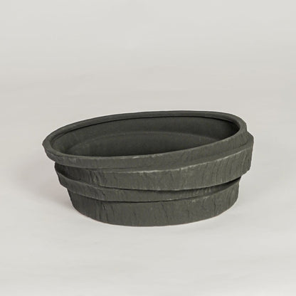 Modern black ceramic decorative bowl with textured stone design ideal for fruit display dining table centerpiece and kitchen decor styling.