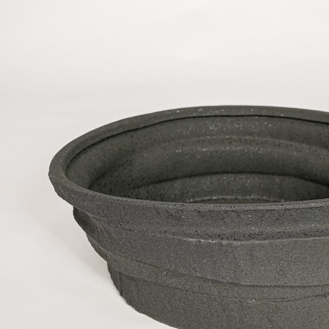 Black ceramic decorative bowl with textured stone surface perfect for elegant dining table centerpiece and interior decor styling.