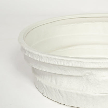 Close view of white ceramic round tray highlighting textured layered rim and smooth matte finish.
