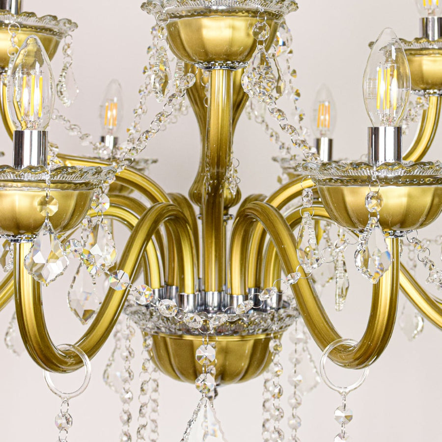 Closeup of gold metal chandelier arms and crystal drops showing fine detailing for premium home lighting.