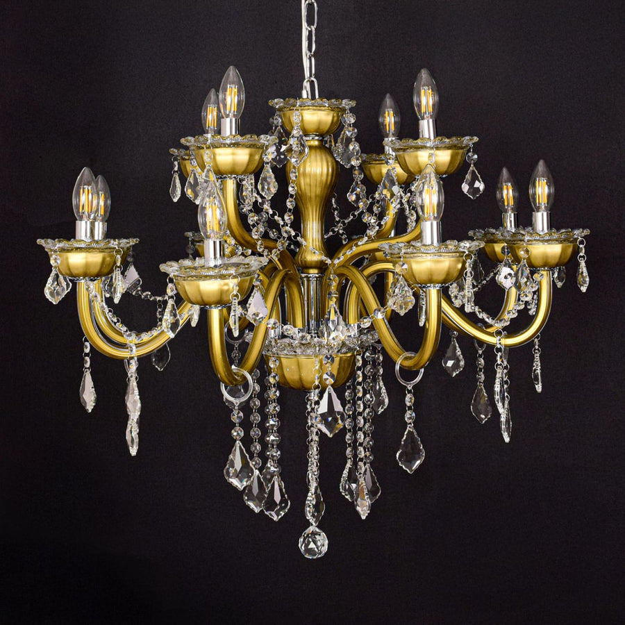 Gold metal chandelier with clear crystal drops displayed on a black background for a bold luxurious decor effect.