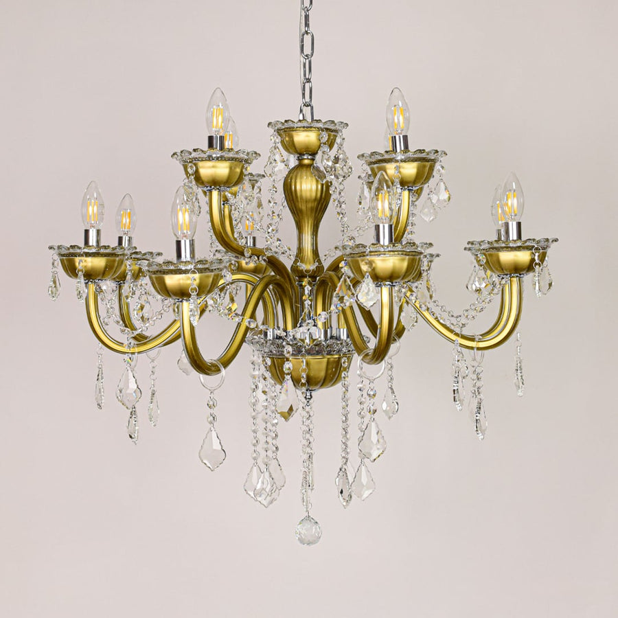 Gold metal chandelier with ornate arms and crystal drops shown on a white background for elegant home decor inspiration.
