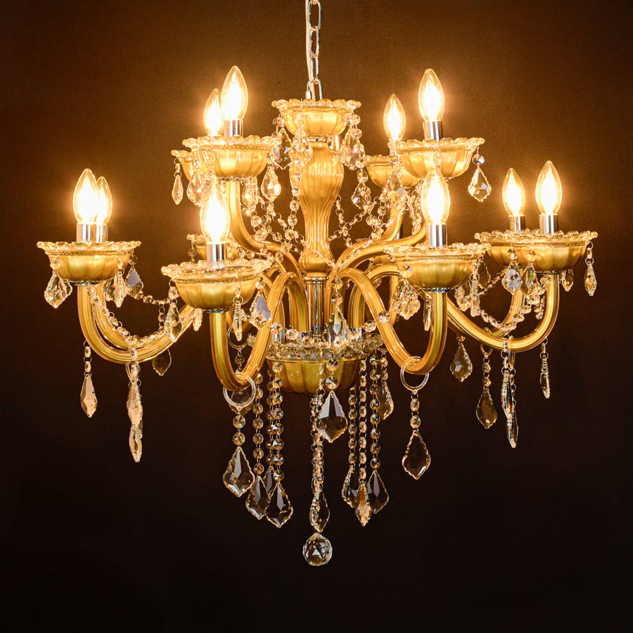 Gold metal chandelier glowing against black background highlighting sparkling crystals and luxury interior lighting.