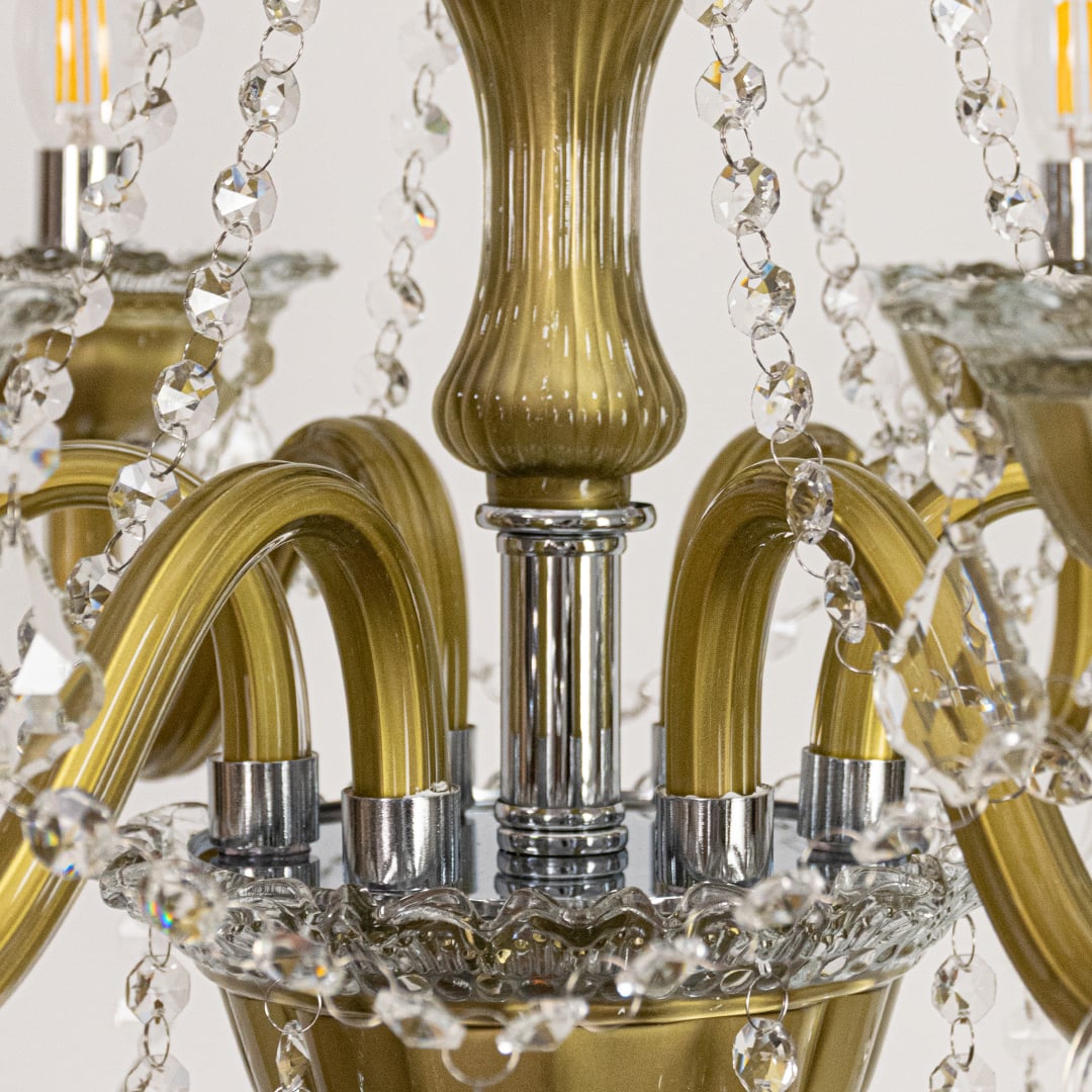 Closeup of vintage gold metal crystal chandelier with detailed arms and beads perfect for luxury interior ceiling lighting.