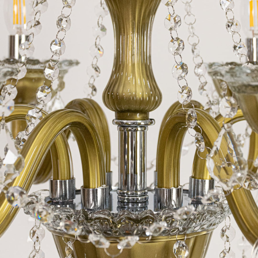 Closeup of vintage gold metal crystal chandelier with detailed arms and beads perfect for luxury interior ceiling lighting.