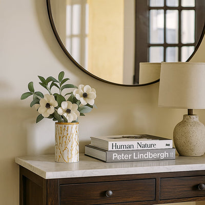 Stylish ceramic jar with golden botanical pattern and wooden lid displayed in a bright minimal setting  adding a refined decorative touch.