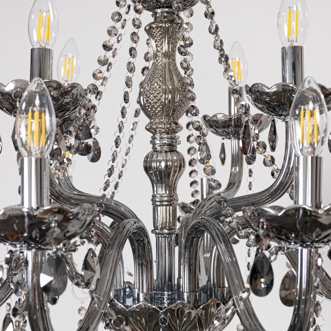 Closeup of chandelier showing smoky crystal droplets and silver detailing highlighting elegant luxury design.
