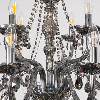 Closeup of chandelier showing smoky crystal droplets and silver detailing highlighting elegant luxury design.