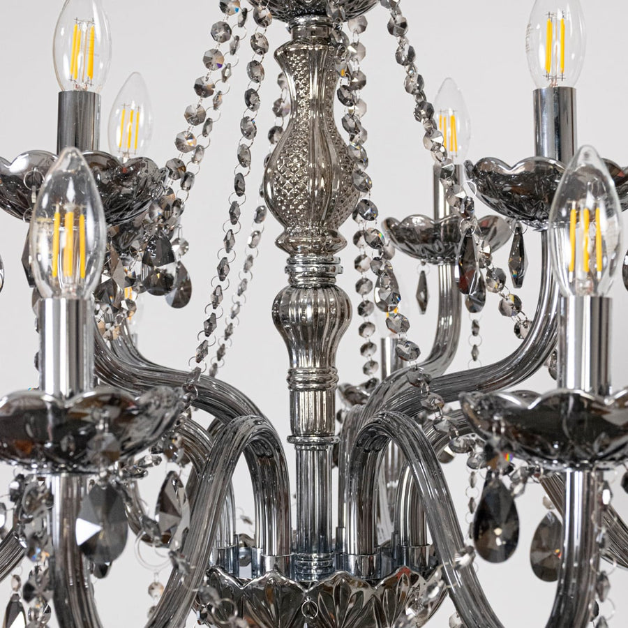 Closeup of chandelier showing smoky crystal droplets and silver detailing highlighting elegant luxury design.