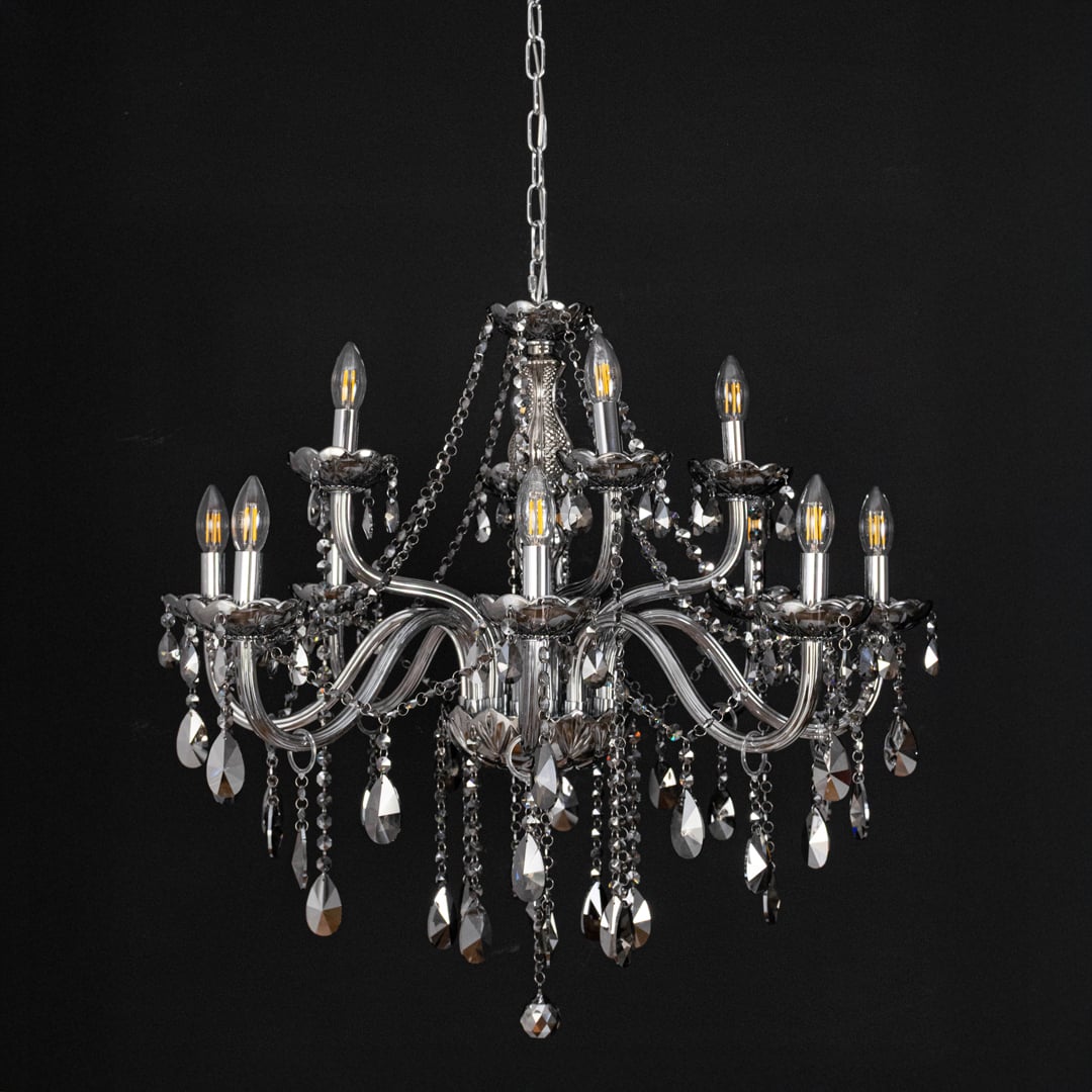 Chandelier with smoky crystal and silver finish displayed off against black background for stylish interior style.