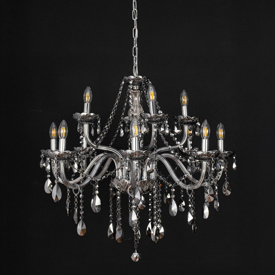 Chandelier with smoky crystal and silver finish displayed off against black background for stylish interior style.