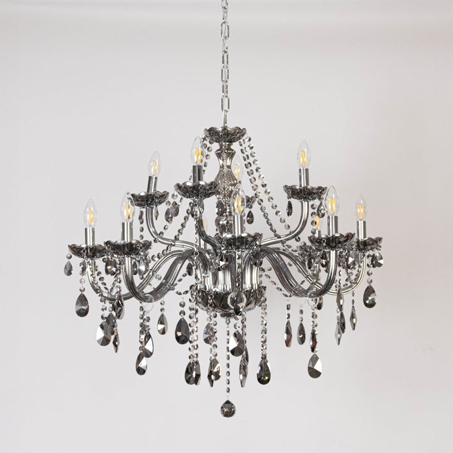 Classic chandelier with smoky crystal accents and silver detailing displayed off on white background decor.