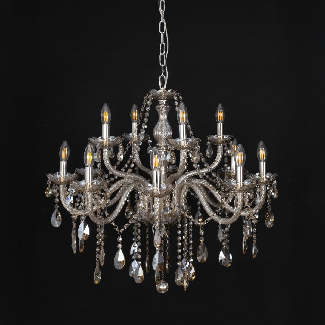 Chandelier with golden crystal detailing displayed off against black background for modern decorative style.