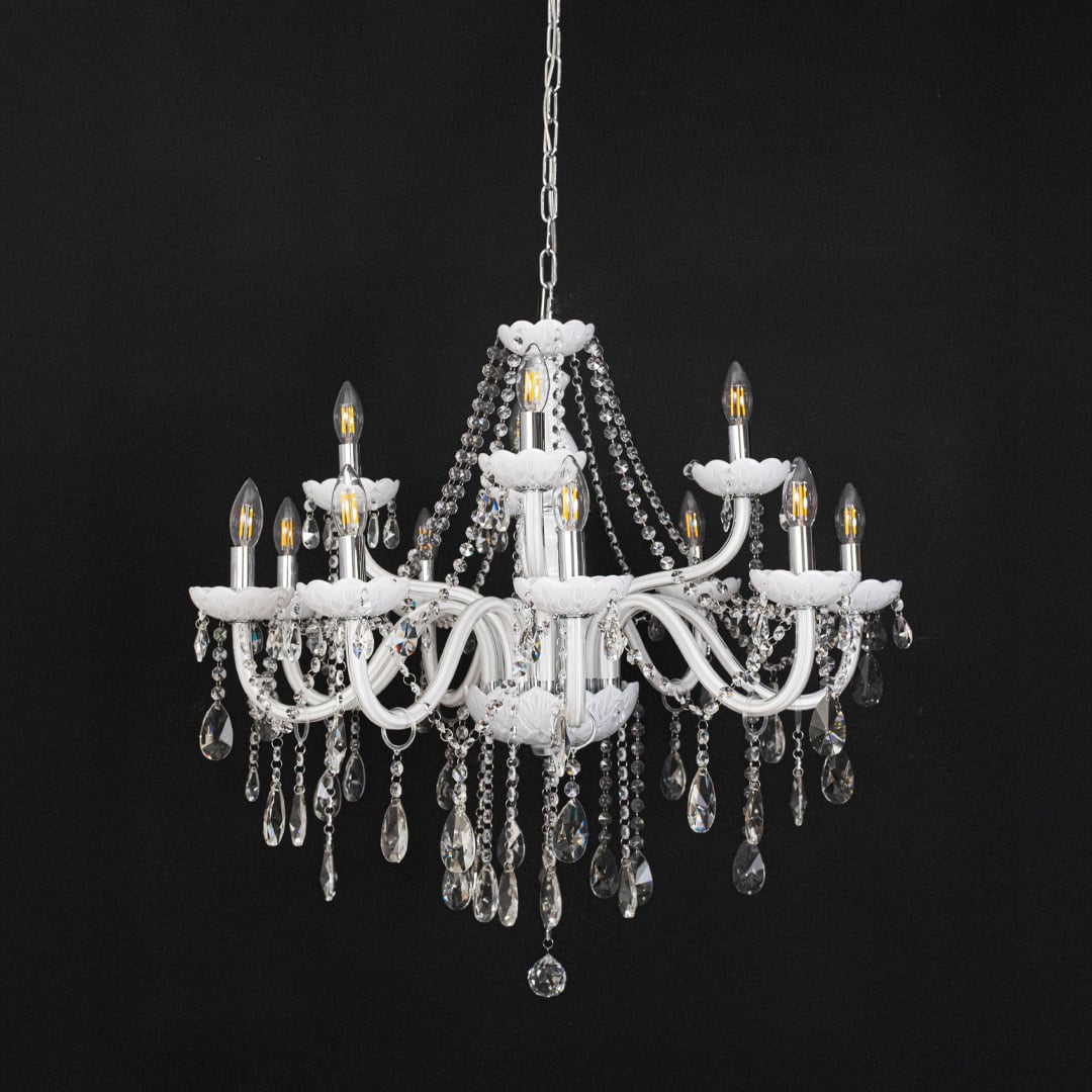 White chandelier with lights off highlighting crystal drops and glass arms against a black background.