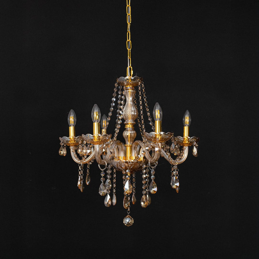 Golden chandelier with crystal detailing displayed off against black background for stylish interior lighting.