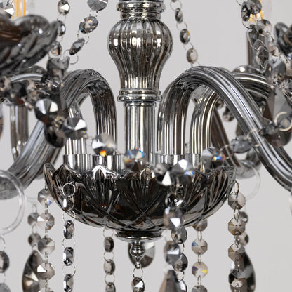 Closeup of chandelier with smoky grey frame and crystal droplets highlighting luxury decorative light design.