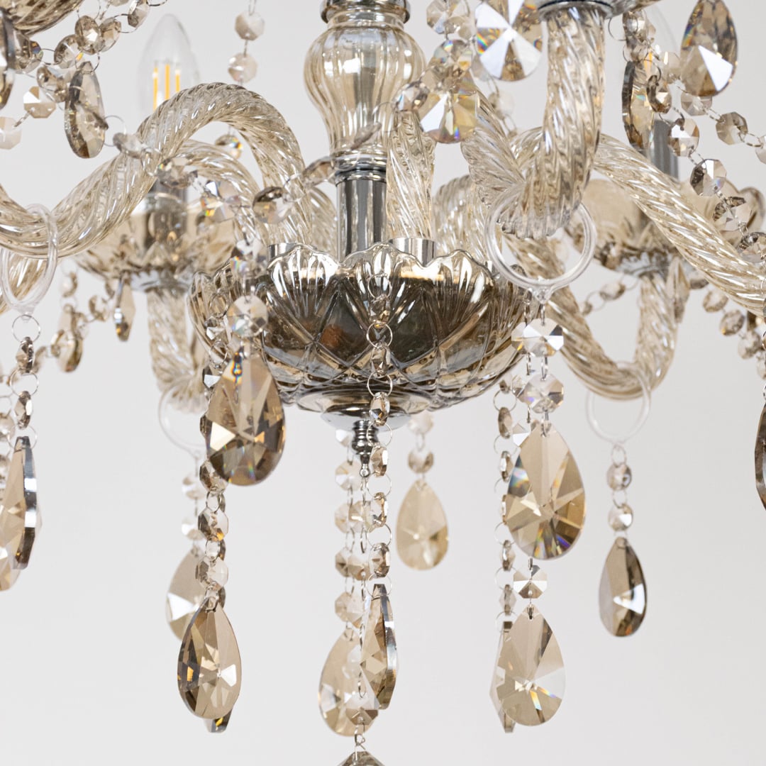 Closeup of chandelier with golden frame and crystal droplets showing elegant detailed luxury light design.