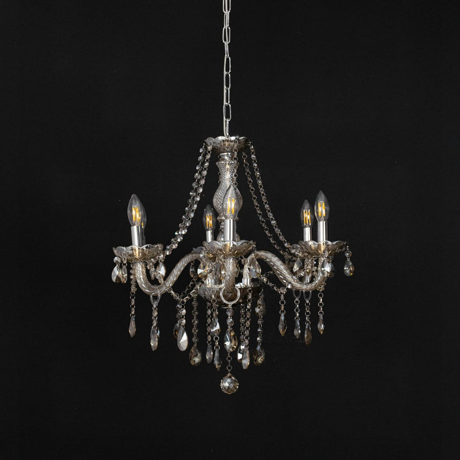 Golden chandelier with crystal detailing displayed off against black background for classic modern home style.
