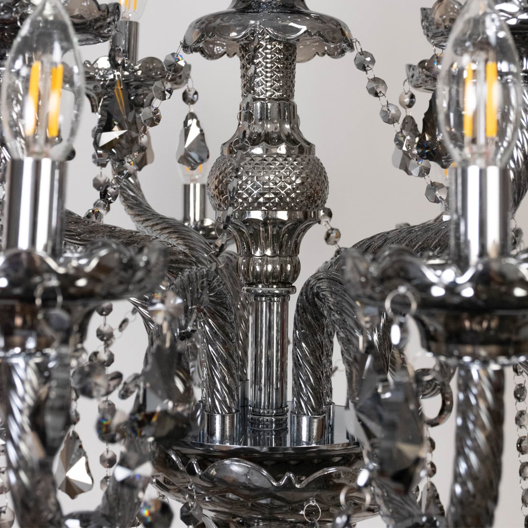 Closeup of black chandelier showing candle bulbs crystal details and decorative glass body for ceiling decor.