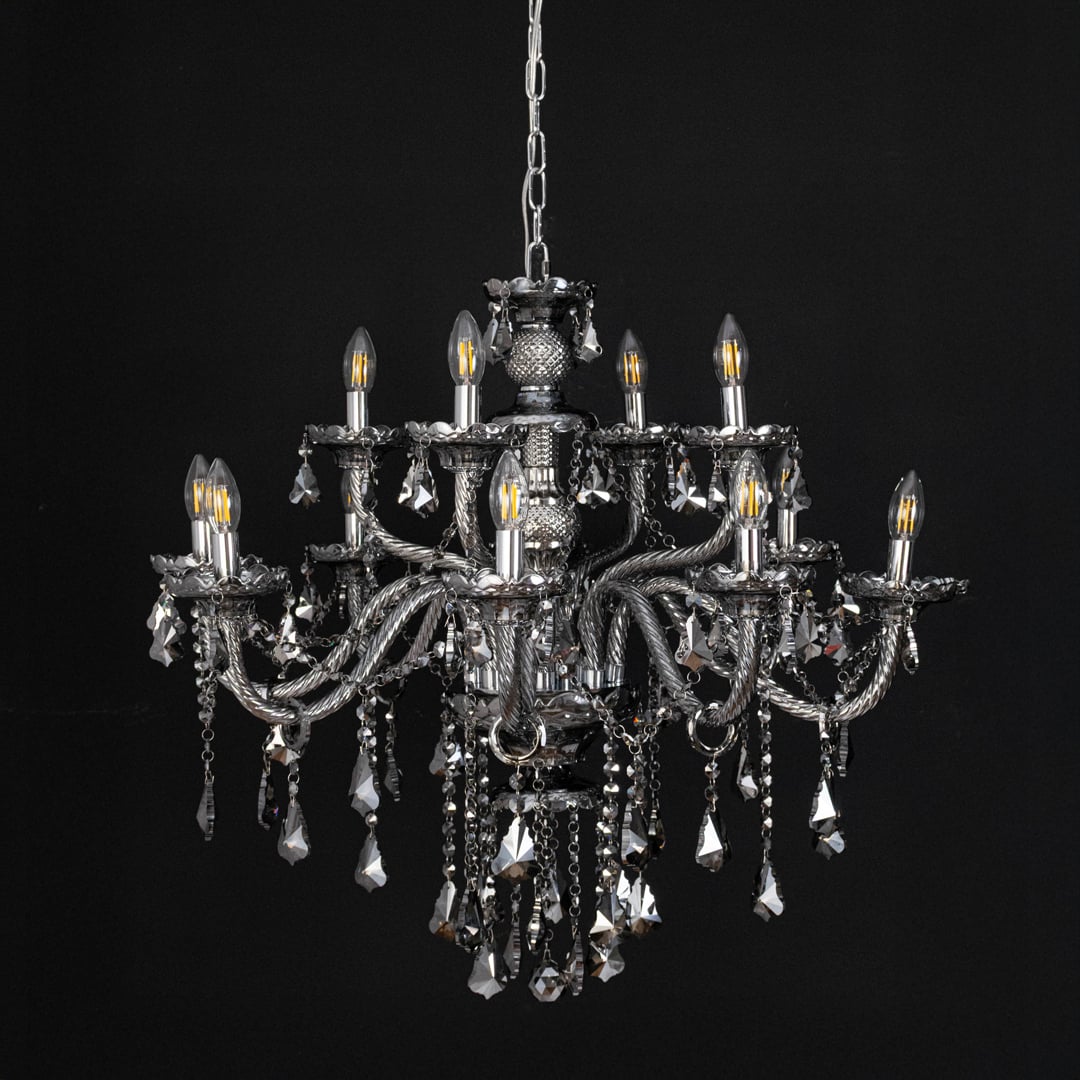 Black chandelier with lights off highlighting crystal design and glass arms photographed on black background.