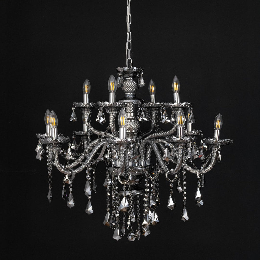 Black chandelier with lights off highlighting crystal design and glass arms photographed on black background.