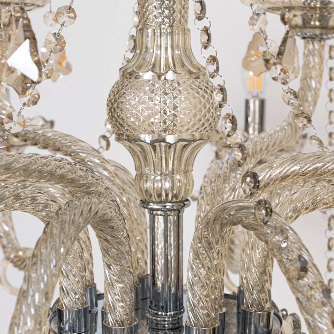 Closeup of chandelier showing crystal beads and candle style lights with elegant glass arms for home decor.