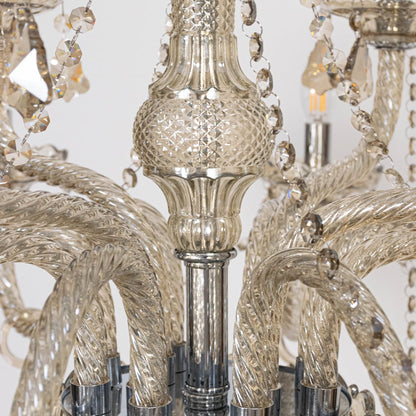 Closeup of chandelier showing crystal beads and candle style lights with elegant glass arms for home decor.
