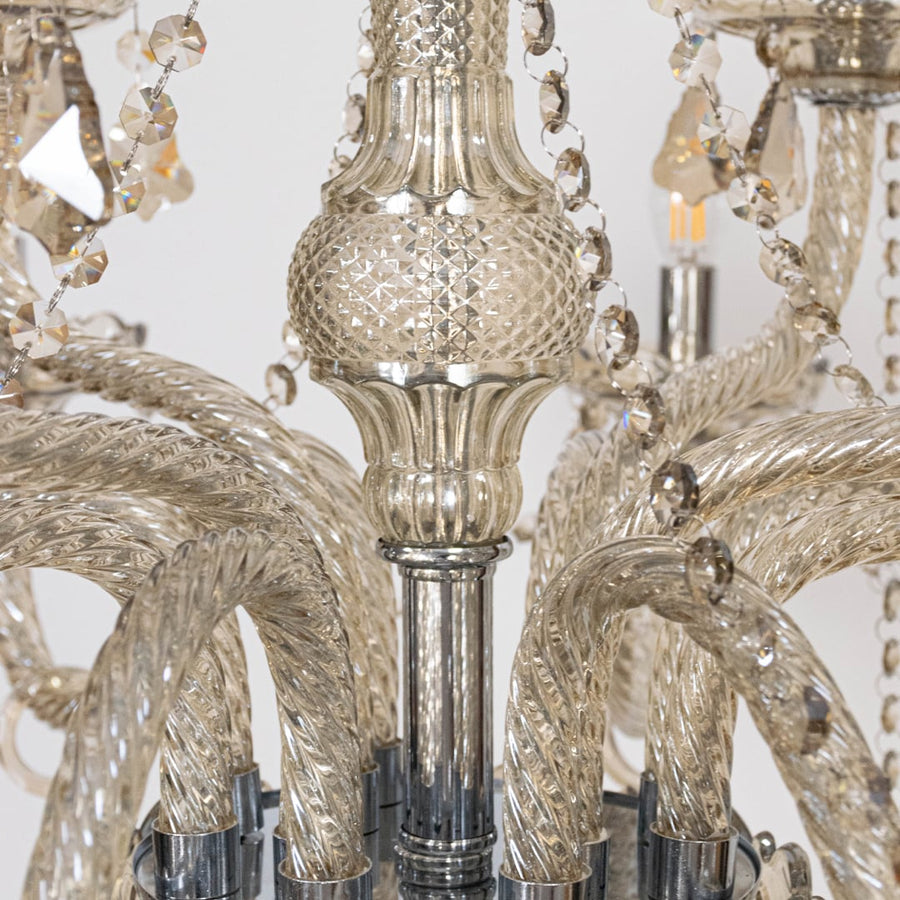 Closeup of chandelier showing crystal beads and candle style lights with elegant glass arms for home decor.