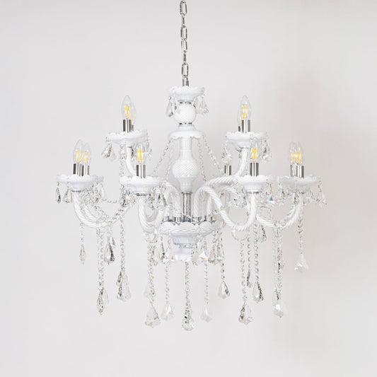 White chandelier with lights off showcasing crystal chains and glass arms photographed on plain white background.