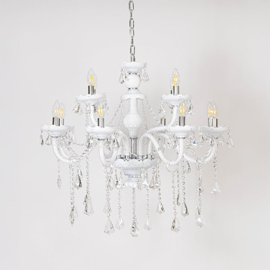 White chandelier with lights off showcasing crystal chains and glass arms photographed on plain white background.