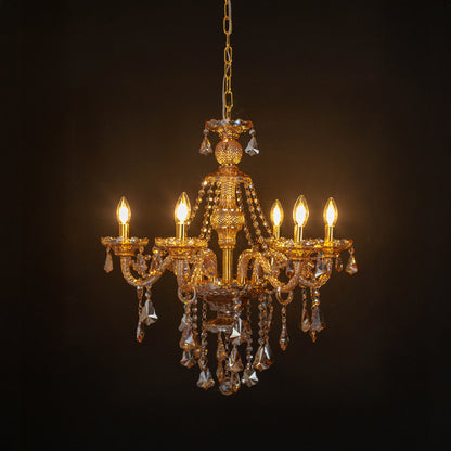 Gold crystal chandelier with radiant candle bulbs and shimmering crystal drops creating dramatic luxury interior lighting.