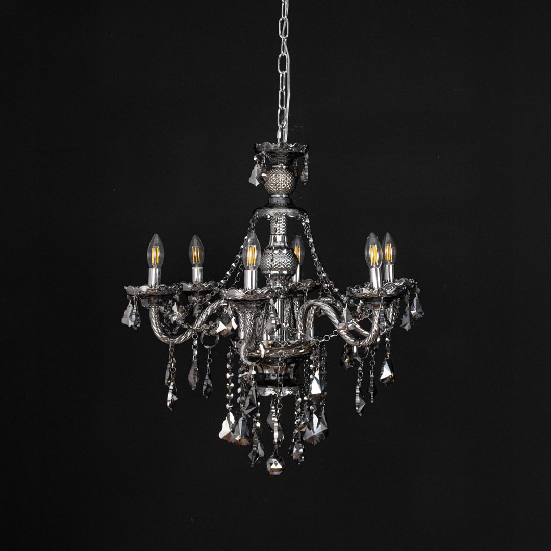 Chandelier displayed with lights off on black background showcasing crystal and metal details.