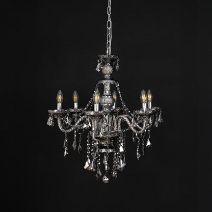 Chandelier displayed with lights off on black background showcasing crystal and metal details.