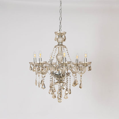 Golden chandelier with ornate crystal accents displayed off on white background for elegant lighting style.