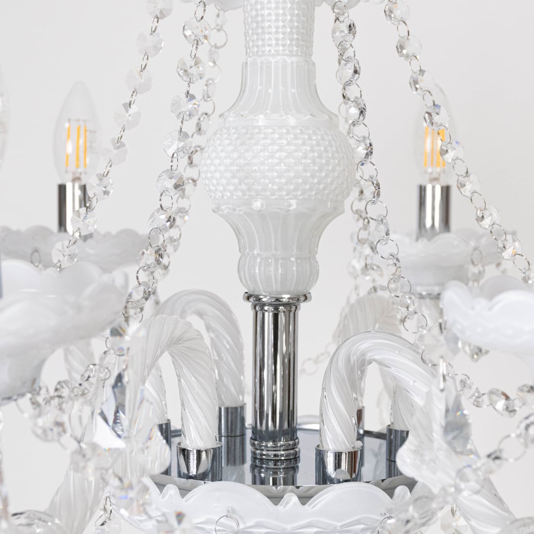 Closeup of chandelier showing crystal chains and candle lights with detailed craftsmanship for home ceiling decor.