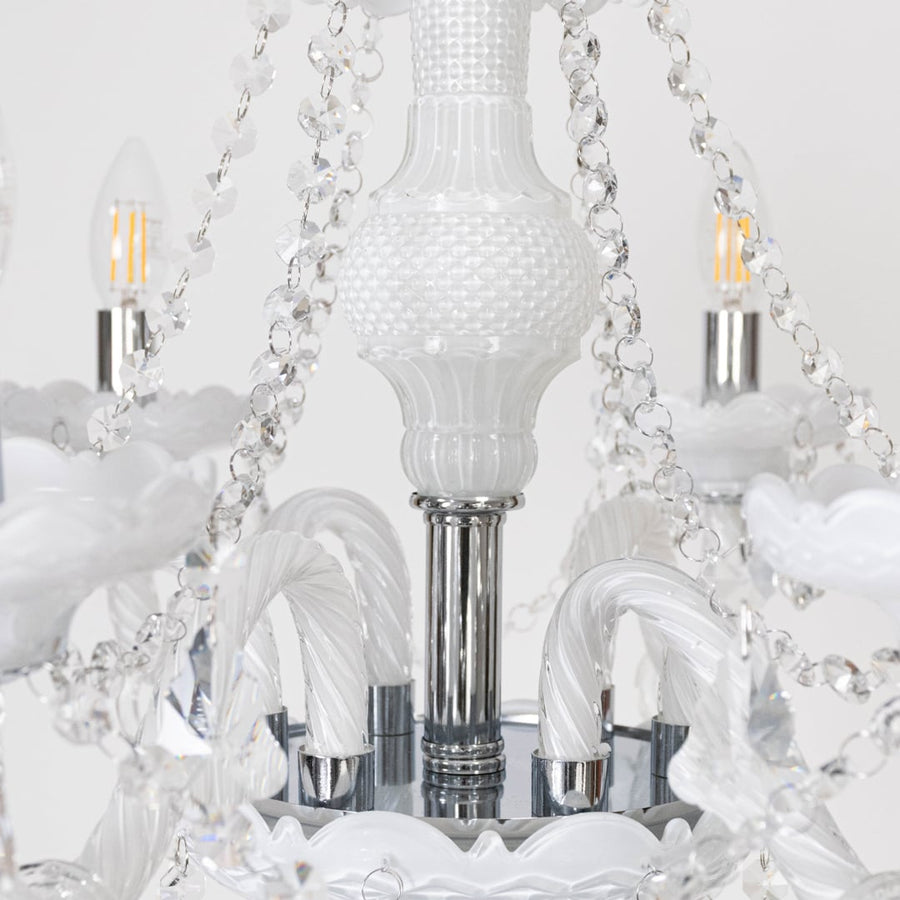 Closeup of chandelier showing crystal chains and candle lights with detailed craftsmanship for home ceiling decor.