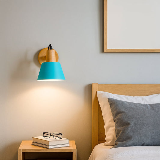 Wall mounted bedside light with turquoise shade and wooden base creating a warm reading glow beside a modern bed and nightstand in a calm minimalist bedroom setting.