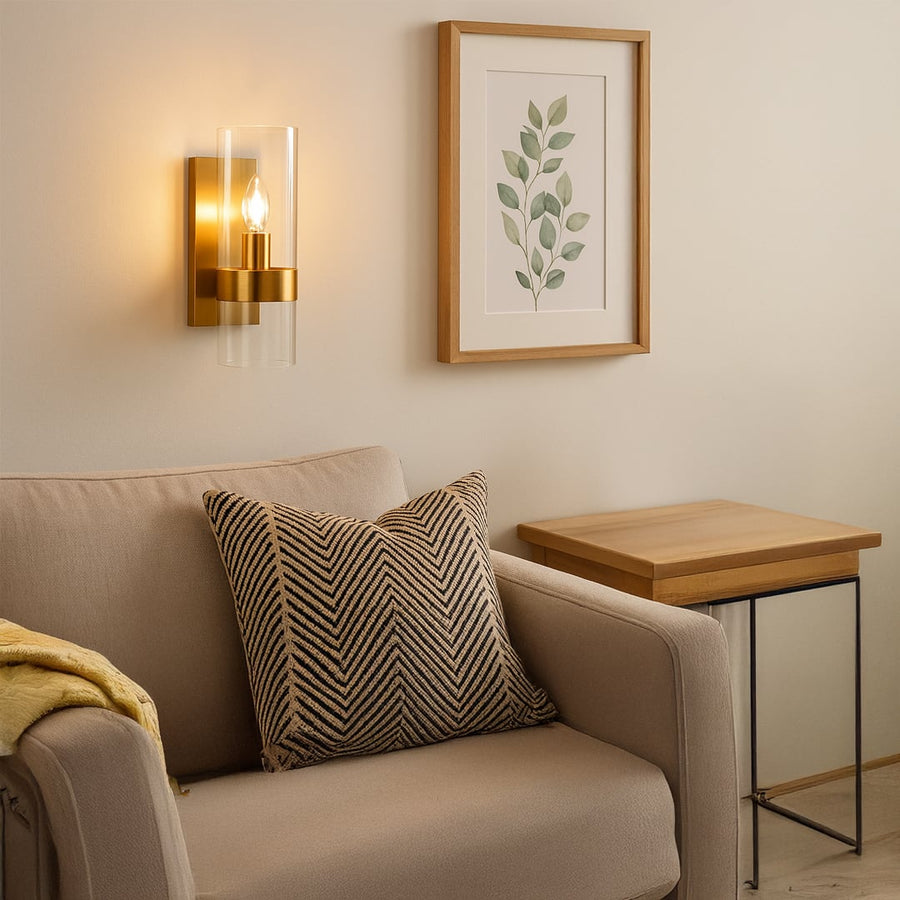 A warm wall light glowing softly beside a beige sofa and framed artwork creating a calm inviting living space with golden accents and a modern aesthetic.