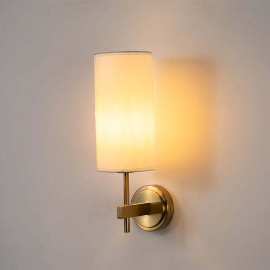 Elegant wall light in gold metal finish with fabric shade for bedroom or living room ambient lighting decor white background.