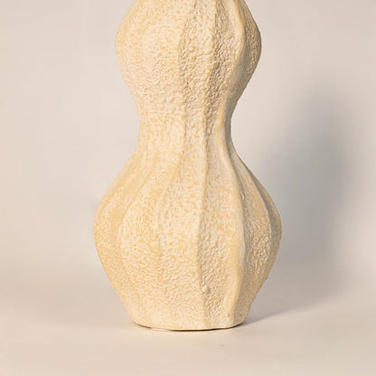 Close up of textured wavy vase emphasizing detailed curves hand sculpted grooves and ceramic texture.